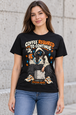 Female model wearing a black Coffee Required to Continue graphic T-shirt with a hooded female character charging from an orange coffee cup.