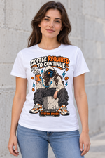 Female model wearing a white Coffee Required to Continue graphic T-shirt with a hooded female character charging from an orange coffee cup.